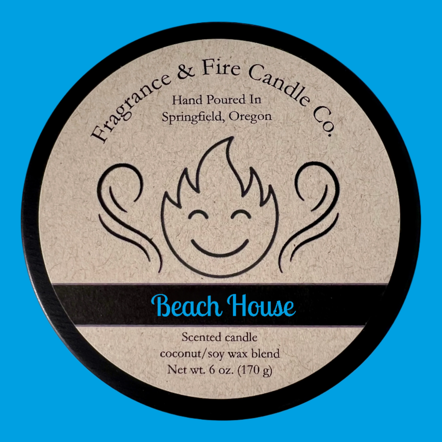 Top of candle lid with label that shows company logo of a smiling flame and aroma swirls rising up and the company name Fragrance & Fire Candle co. over the text "Hand poured In Springfield, OR". The name of the candle is Beach House and there is text that also reads "Scented candle, coconut/soy wax blend, Net wt. 6 oz. (170 g).