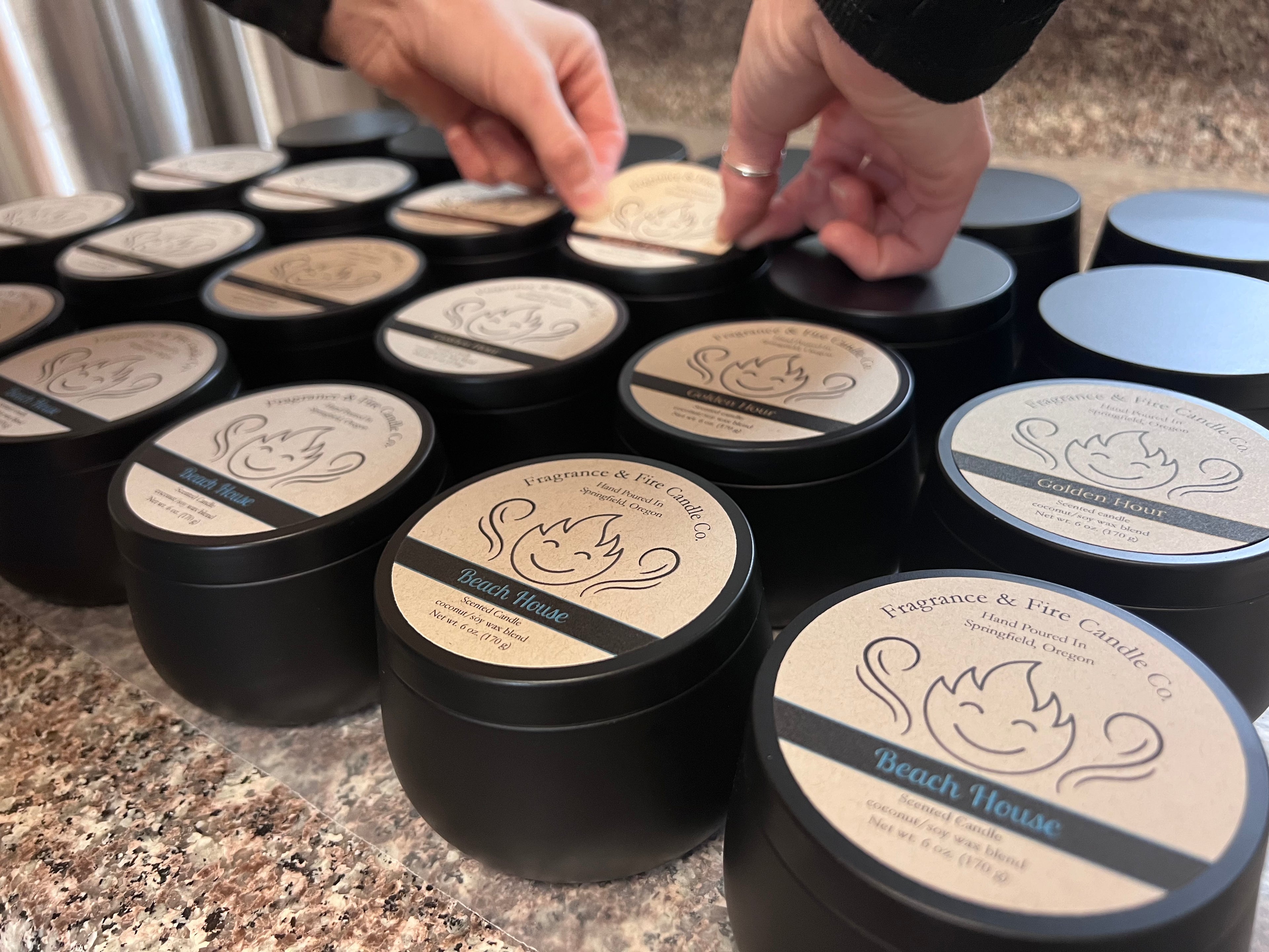 Fragrance & Fire candles being labeled by hand.