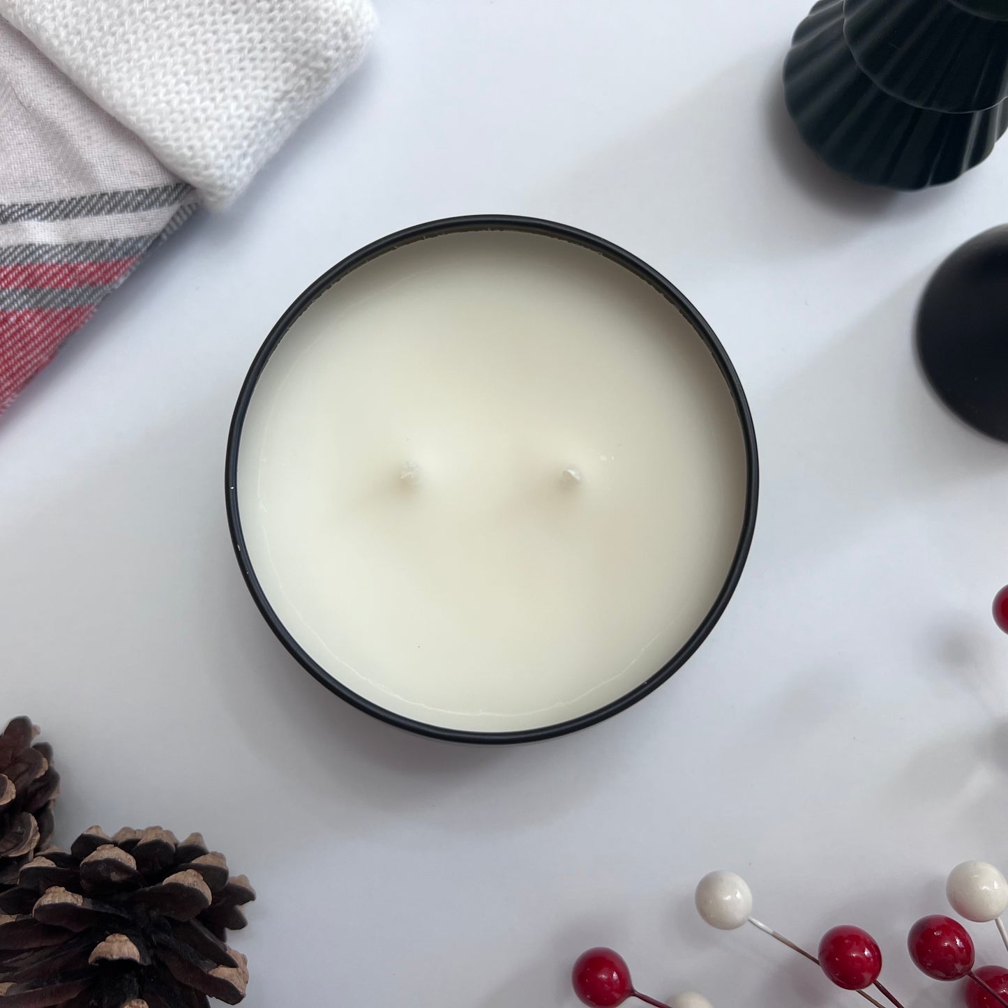 Top view of Fragrance & Fire candle unlit surrounded by christmas decor.