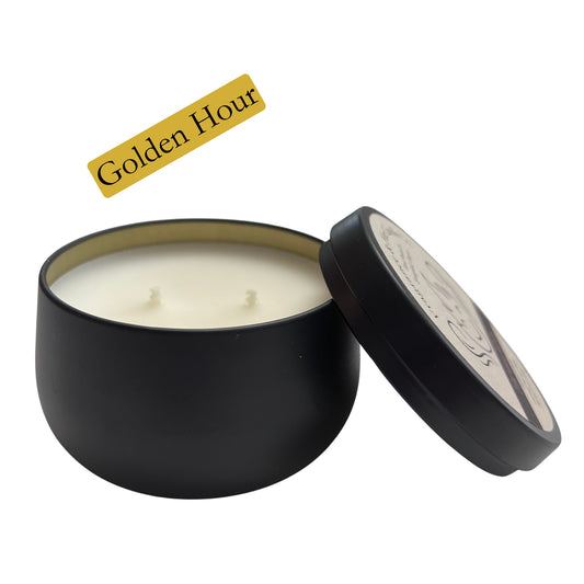 Fragrance & Fire Golden hour candle. Black container with gold lining inside. Lid is off, leaning on the side of the candle. 