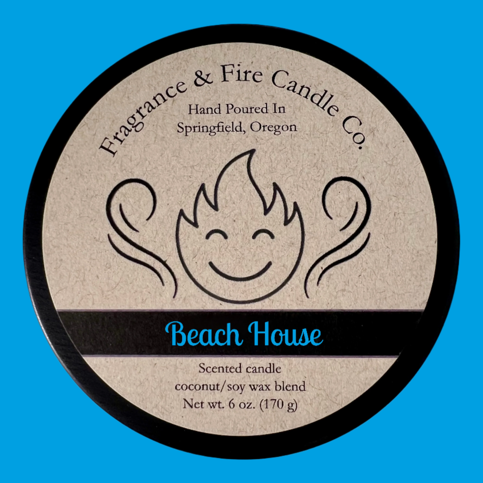 Top of candle lid with label that shows company logo of a smiling flame and aroma swirls rising up and the company name Fragrance & Fire Candle co. over the text "Hand poured In Springfield, OR". The name of the candle is Beach House  and there is text that also reads "Scented candle, coconut/soy wax blend, Net wt. 6 oz. (170 g).