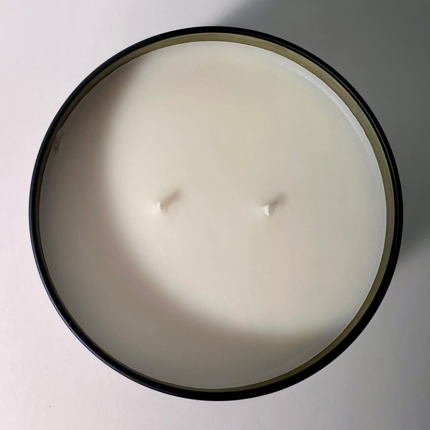 Fragrance & Fire candle with 2 wicks, not lit. Pictured from above shows smooth white top and gold inner lining. 