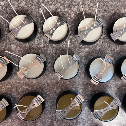 Fragrance & Fire candles viewed from above after pouring. Wicks are untrimmed, held by wick bars. Top row shows cooled candles, bottom row still liquid.