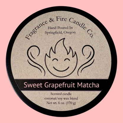 Pale grapefruit pink colored background with round candle top and brown label. Name of the candle on the label is Sweet Grapefruit Matcha.